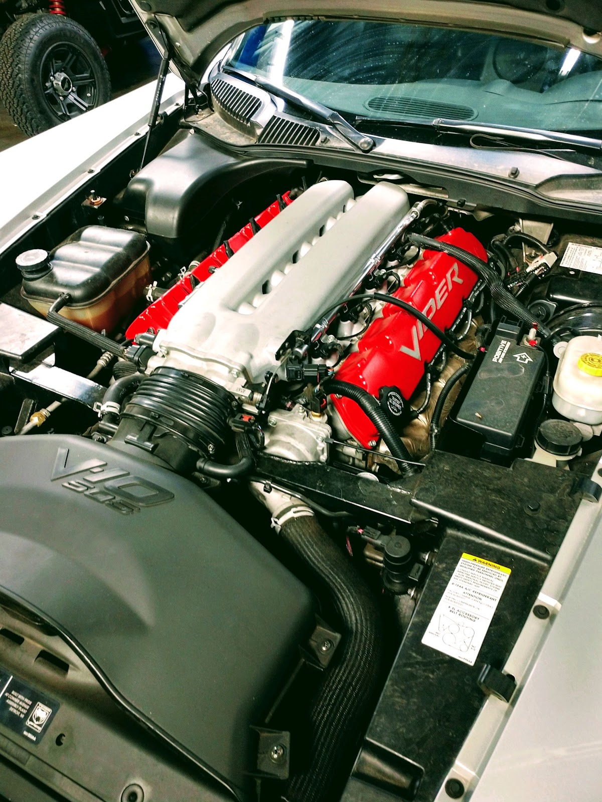 A Dodge Viper engine bay with red V10 valve covers and polished intake